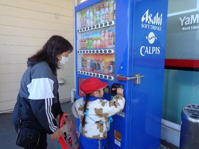 自動販売機にお金を入れています